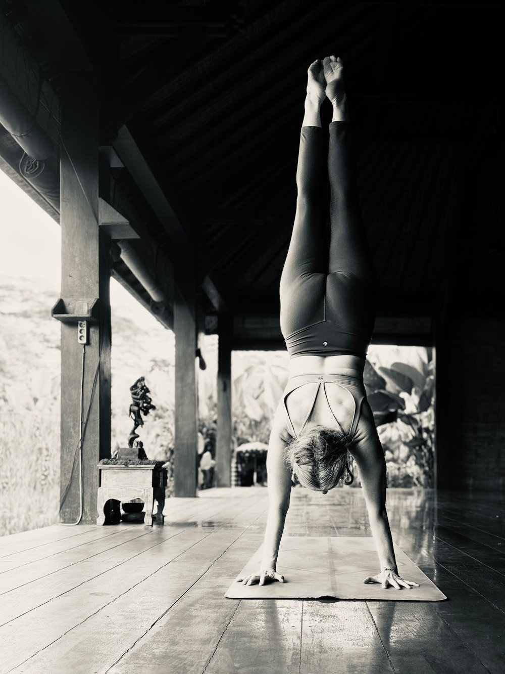 Gretchen in a forearm-supported handstand beneath a covered wooden walkway