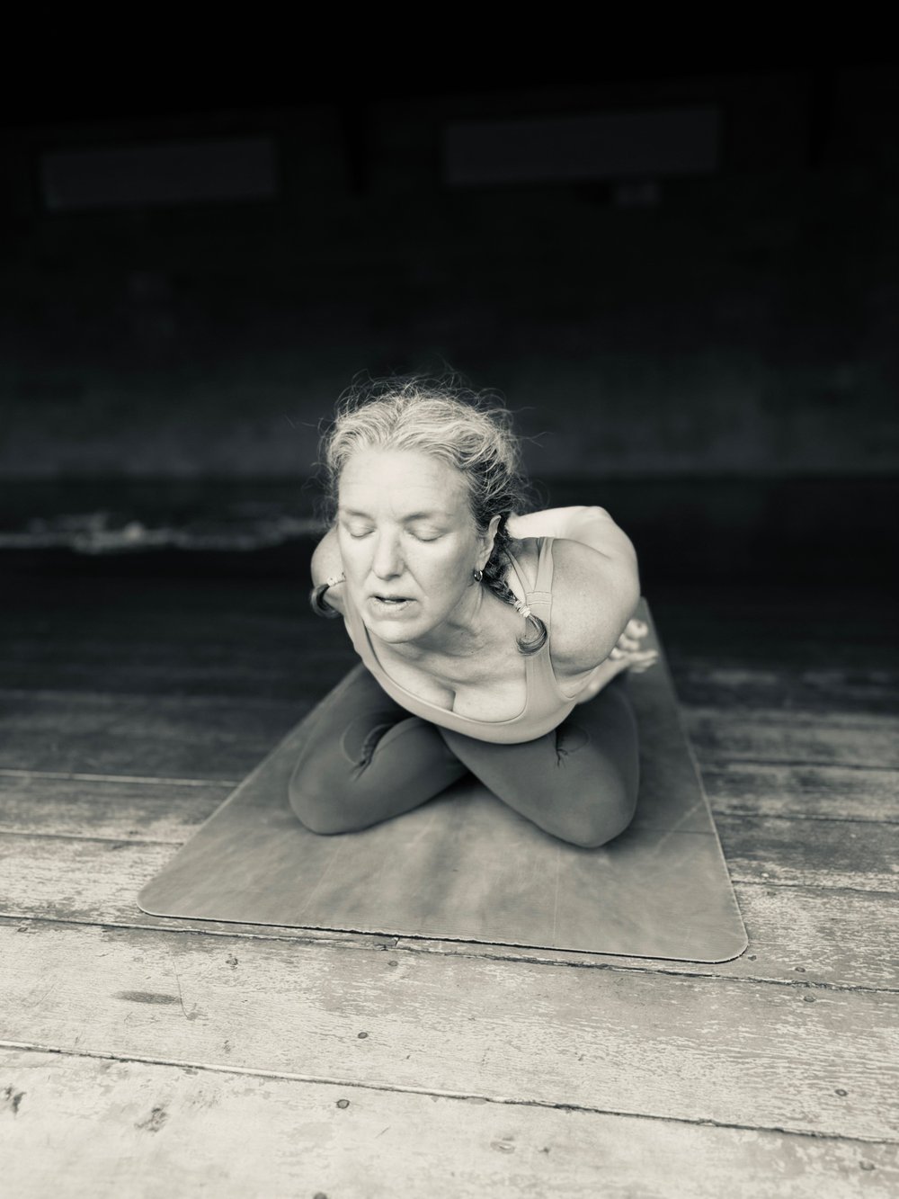 Gretchen in a kneeling backbend on a wooden deck