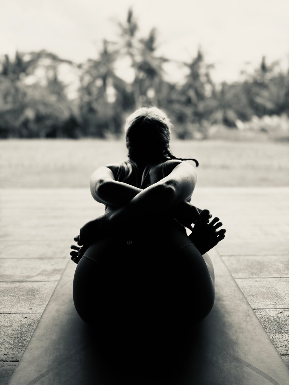 A student seated in quiet reflection facing an open field, practicing stillness
